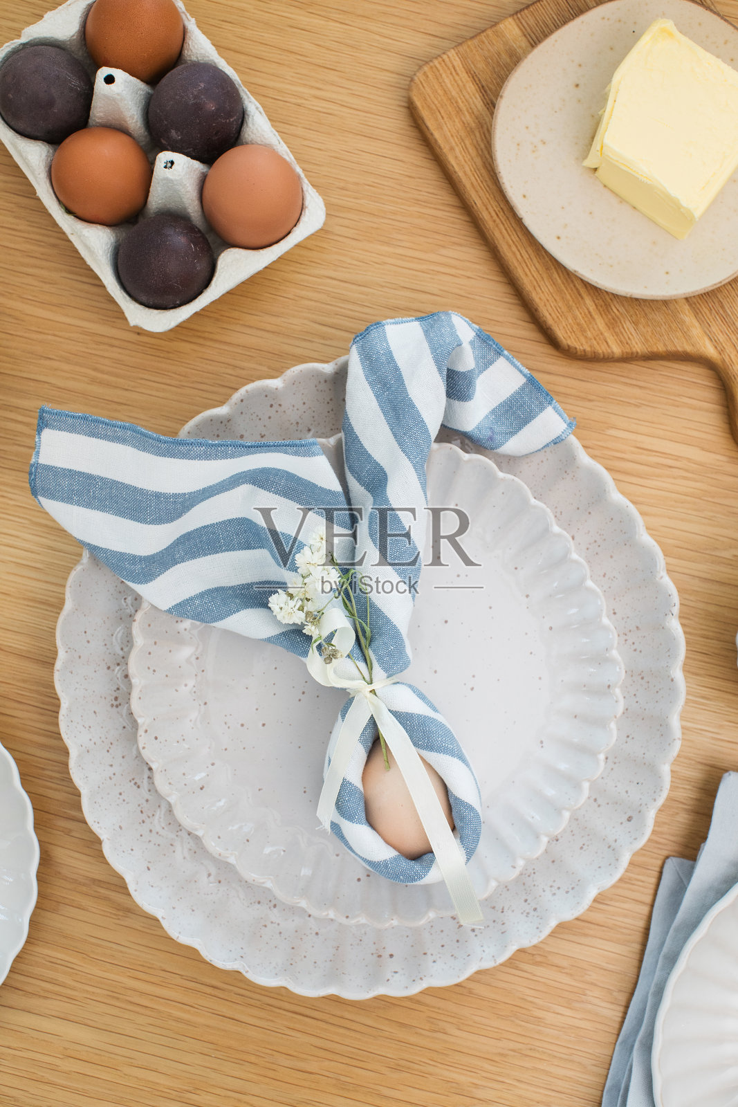 用亚麻餐巾包裹的兔子形状的复活节彩蛋，耳朵翘起。复活节快乐照片摄影图片