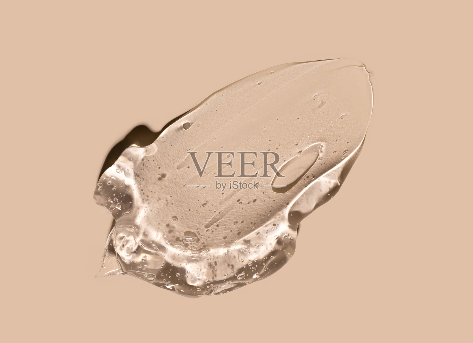 近距离拍摄的米色背景上的化妆品质地凝胶精华涂抹痕迹照片摄影图片