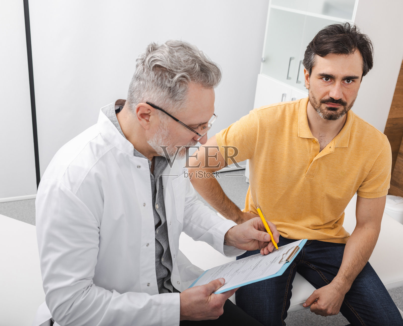 前列腺癌治疗。医生在泌尿科中心与疑似前列腺癌的男性患者进行咨询。照片摄影图片