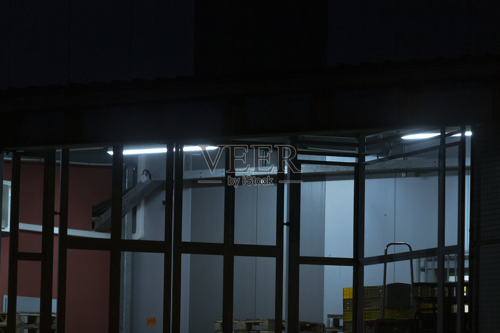 一座装饰着众多窗户的宏伟建筑在夜晚熠熠生辉。照片摄影图片