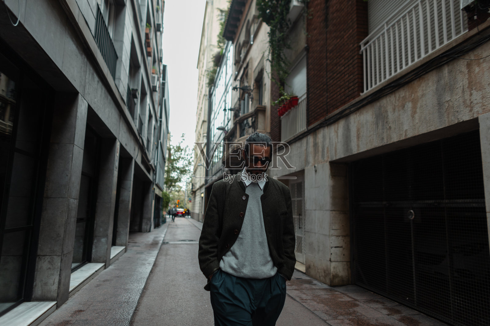 时尚帅气的城市男士穿着时尚休闲服装在巴塞罗那街头漫步。潮流男孩照片摄影图片