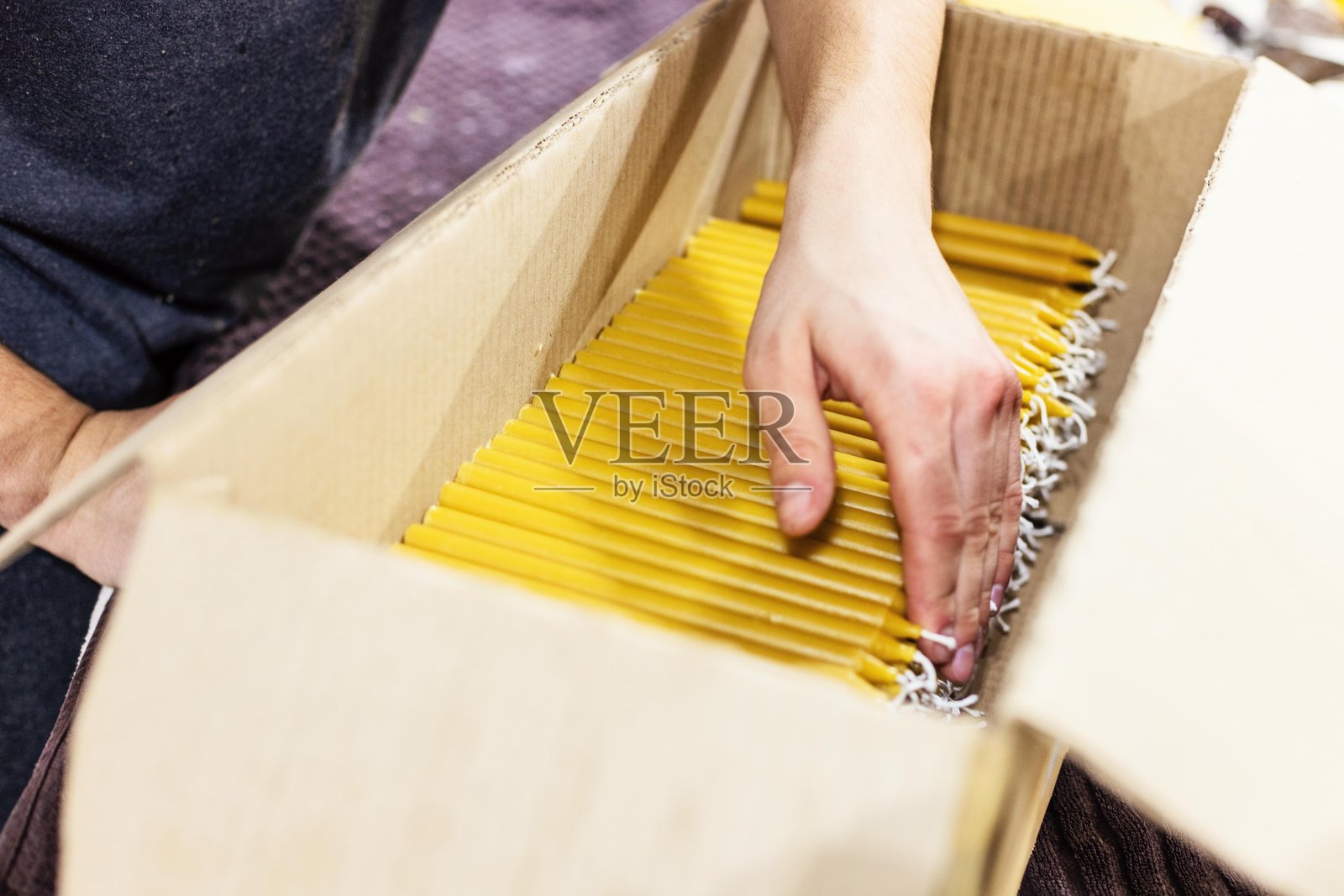 特写镜头：手在纸箱中整理黄色蜡烛照片摄影图片