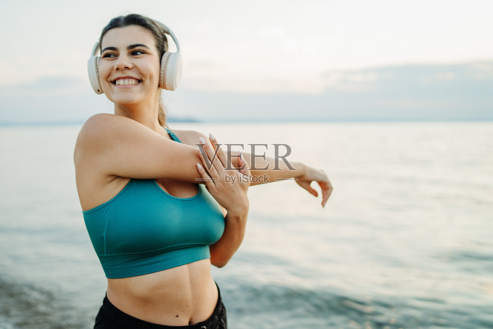 年轻女性在日落时分的海滩上跑步或慢跑照片摄影图片