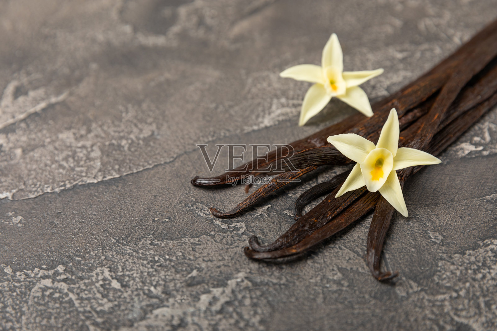 香草荚在纹理背景上。香草花和种子。香草棒。用于糕点和甜点的芳香香料。调味料。留白空间。照片摄影图片