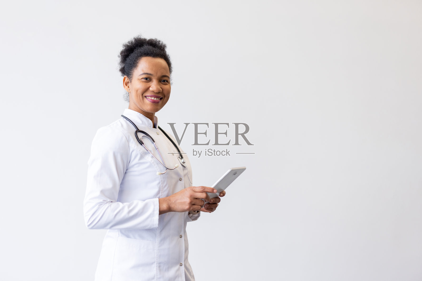 一位熟练的非裔美国医生正在平板电脑上浏览医疗信息照片摄影图片