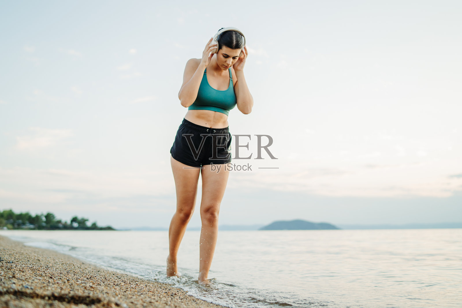 年轻女性在日落时分在海滩上跑步或慢跑照片摄影图片