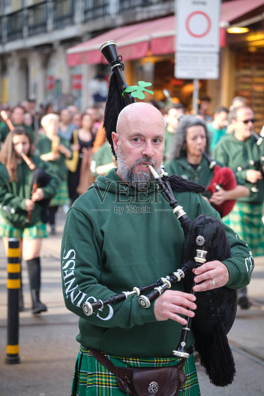 圣帕特里克节庆祝游行 - 穿着爱尔兰裙子、吹着风笛的音乐家在街上行进照片摄影图片