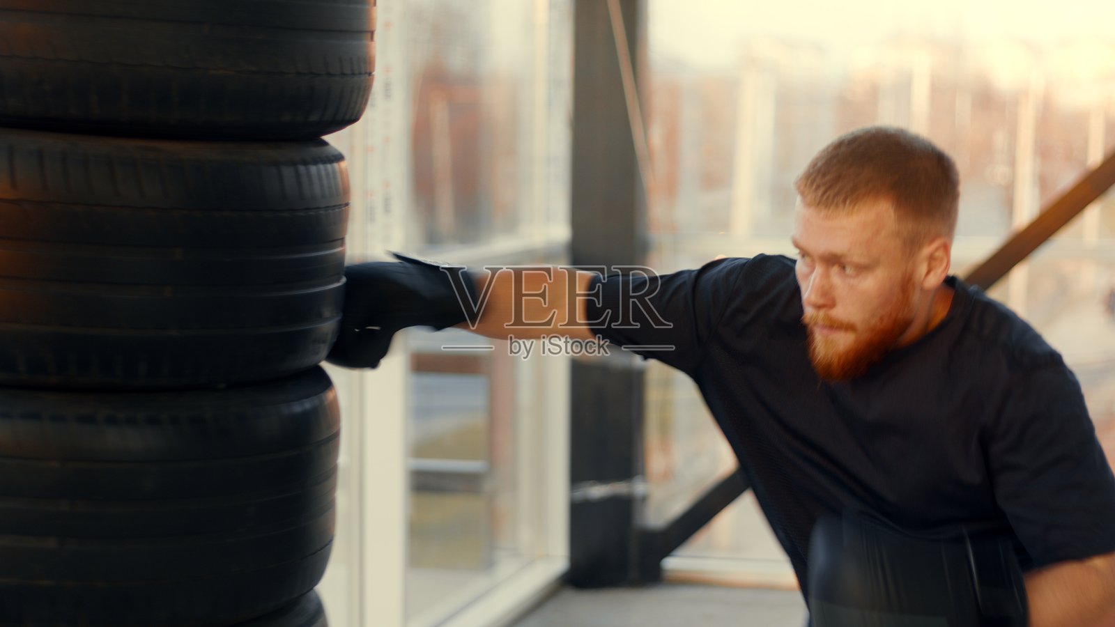 决心坚定的运动员在健身房用轮胎沙袋训练照片摄影图片