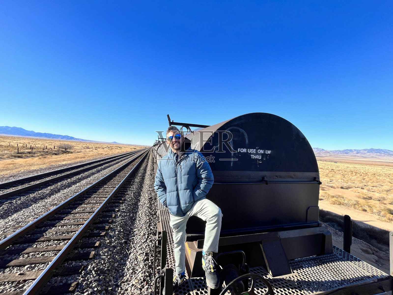 游客在亚利桑那州金曼的66号公路上享受时光，坐在一辆旧火车车厢上照片摄影图片