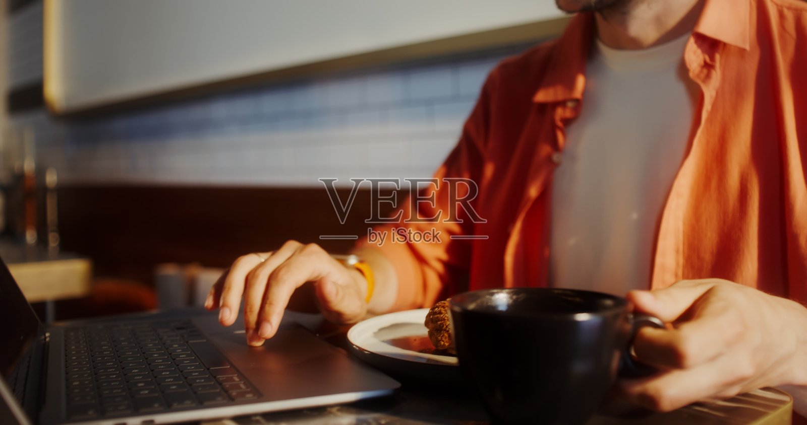 一名男子在咖啡馆里喝咖啡并使用笔记本电脑照片摄影图片