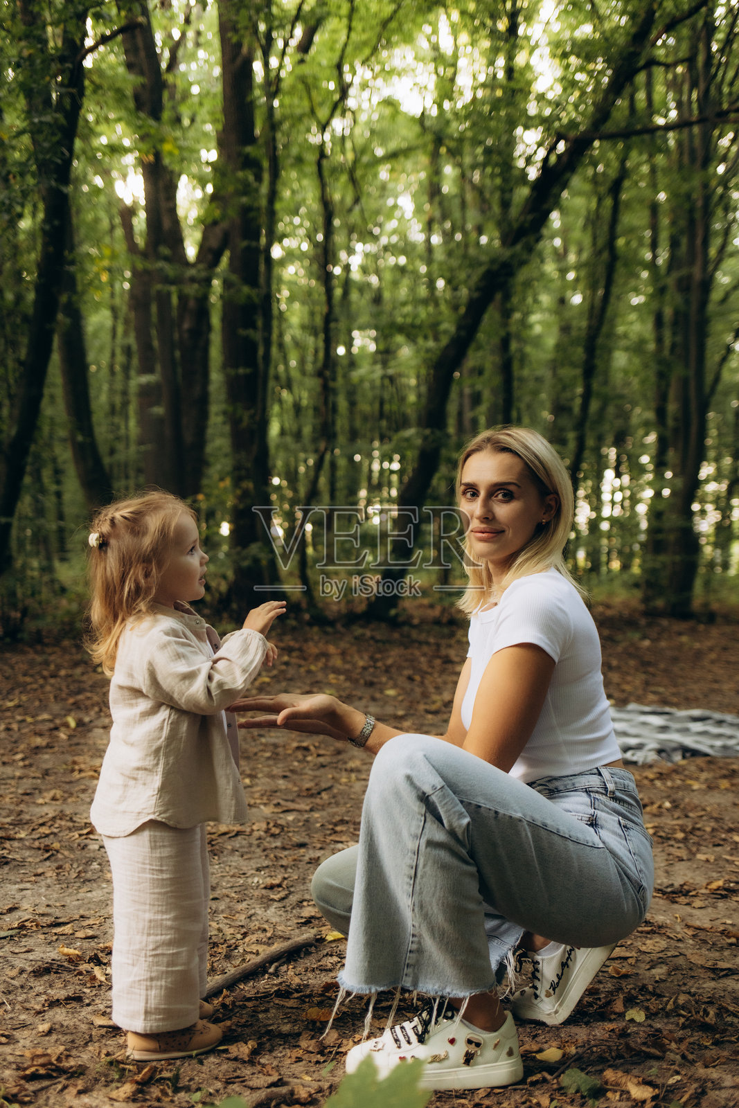 快乐的家庭，母亲和女儿在夏天的公园绿草地上享受自然。照片摄影图片