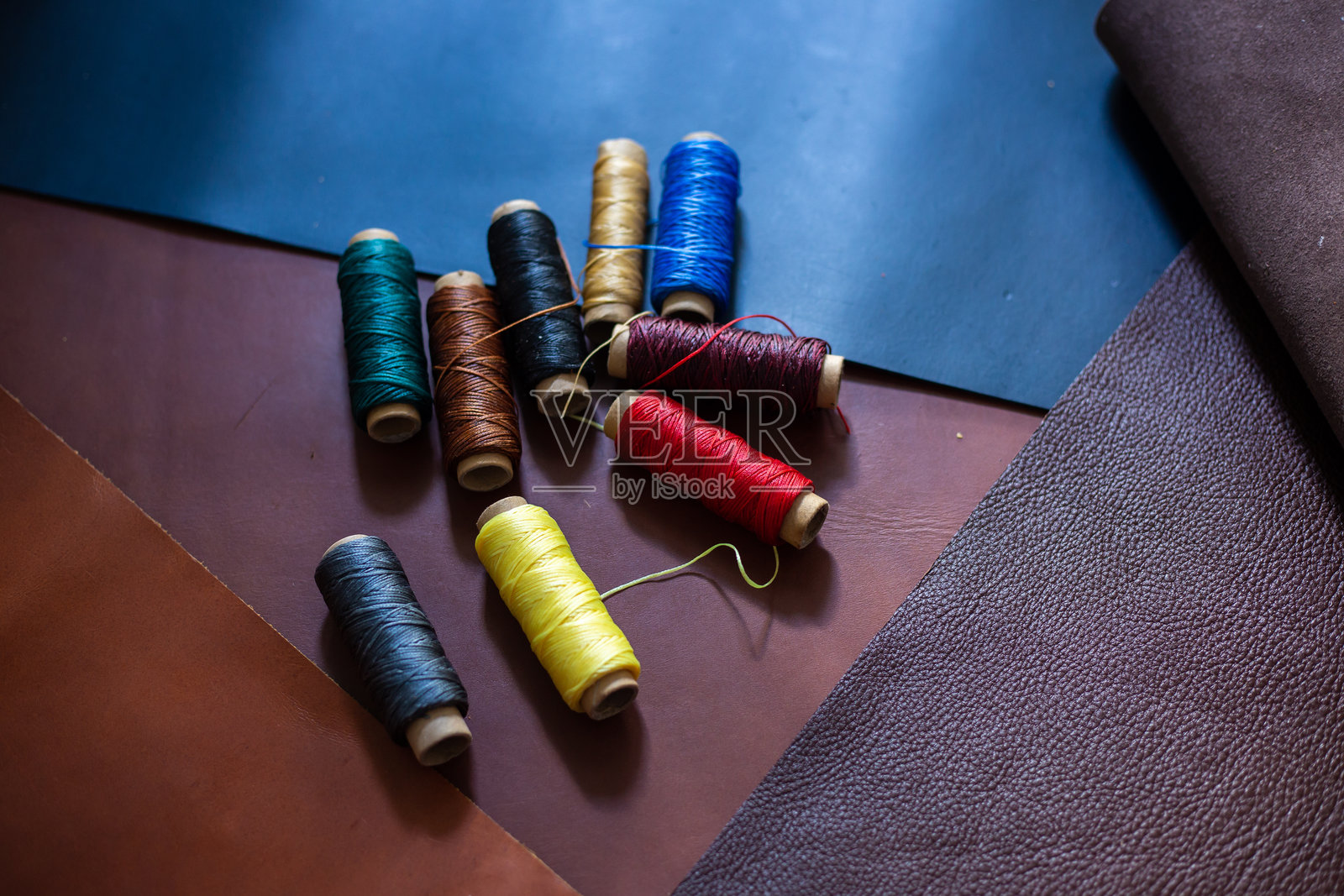 五彩缤纷的亚麻蜡线在皮革背景上的工艺制作照片摄影图片