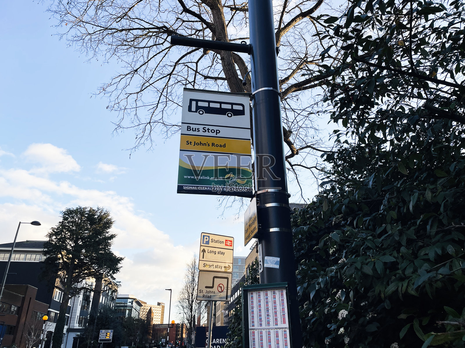 城市街道上的公交站，周围有高楼大厦和标识。照片摄影图片