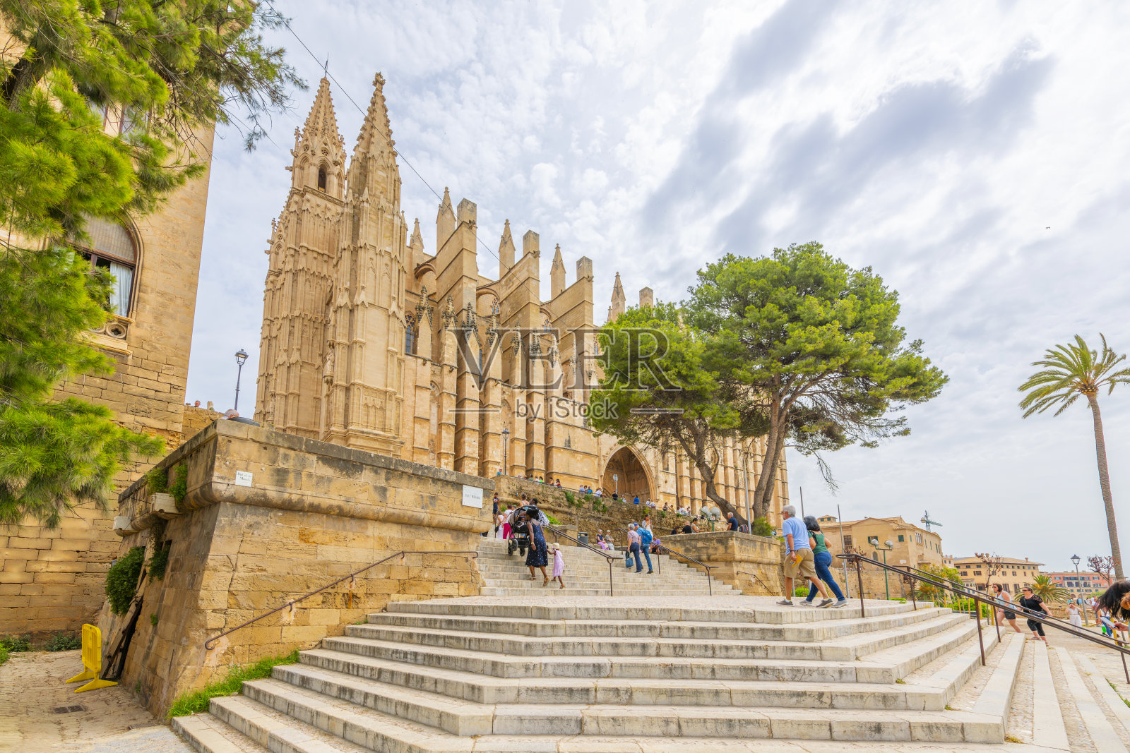 游客在西班牙马略卡岛帕尔马海滨城市的圣玛丽亚大教堂（La Seu）外的宽阔阶梯上行走。照片摄影图片