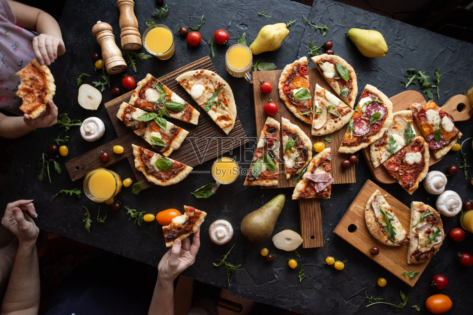 新鲜罗勒的披萨切片，一位女性和一个孩子正在吃披萨照片摄影图片