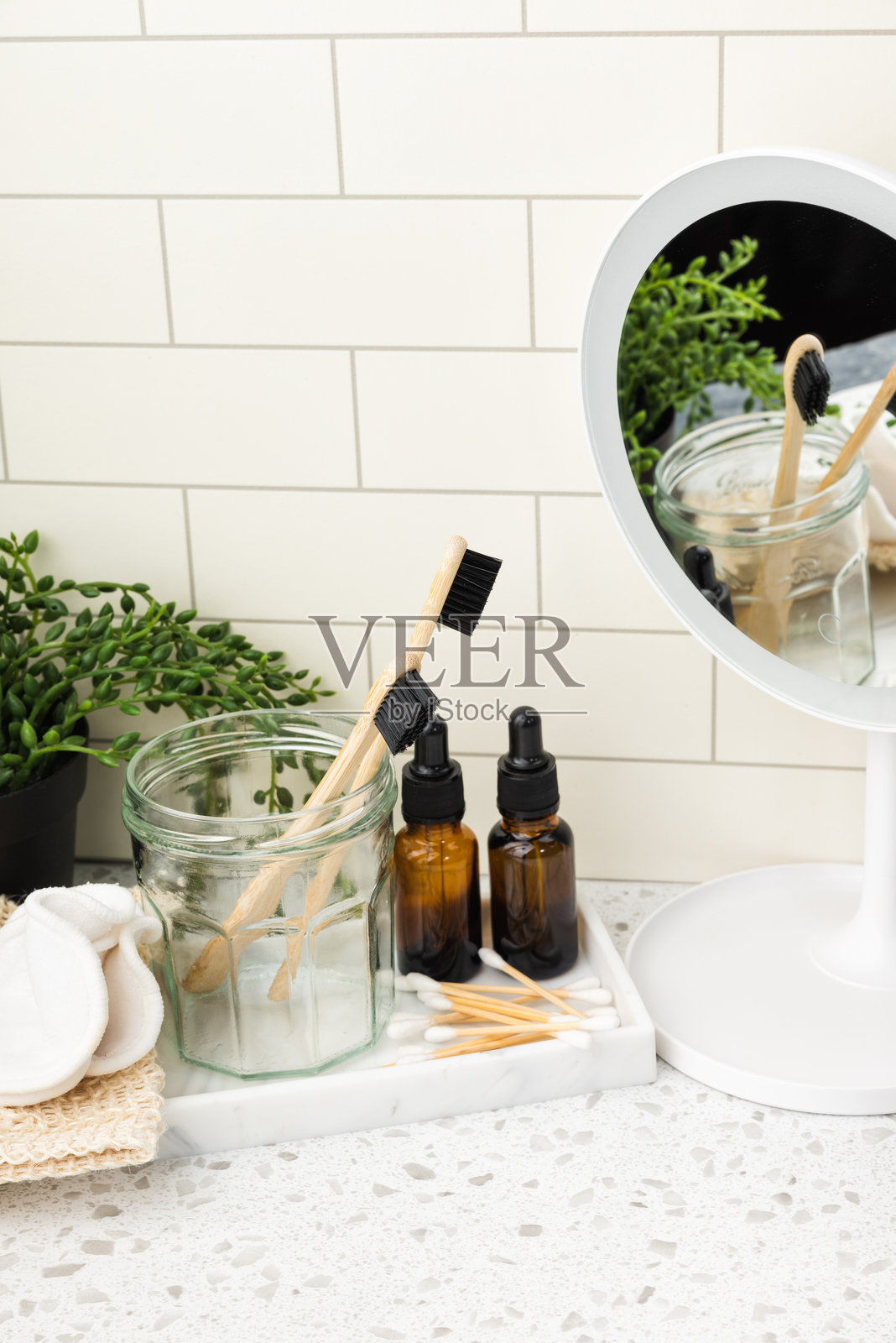 大理石浴室台面上的护肤产品和带LED灯的镜子照片摄影图片