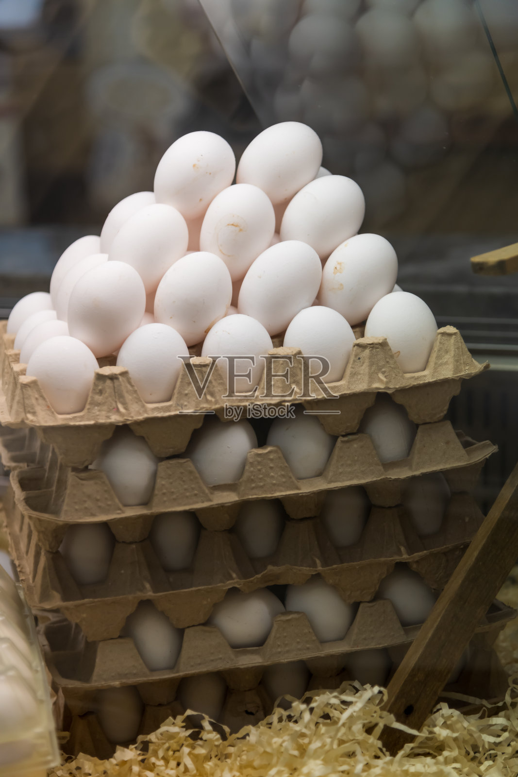 商店展示架上堆叠的装满白色鸡蛋的蛋 carton照片摄影图片