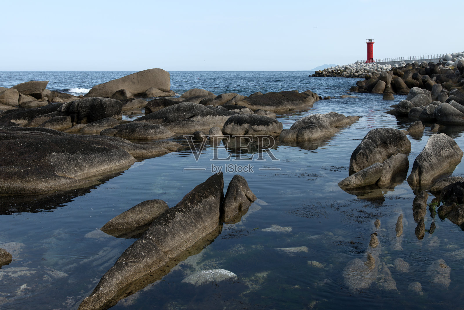 海边的岩石和灯塔照片摄影图片