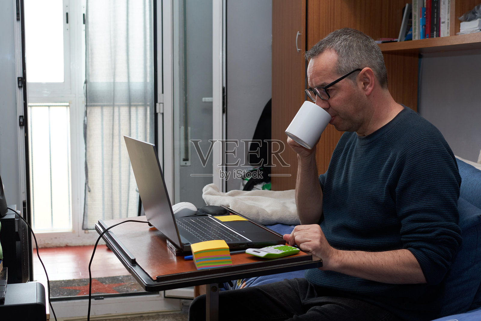 在家工作并喝咖啡的男人正在做笔记照片摄影图片