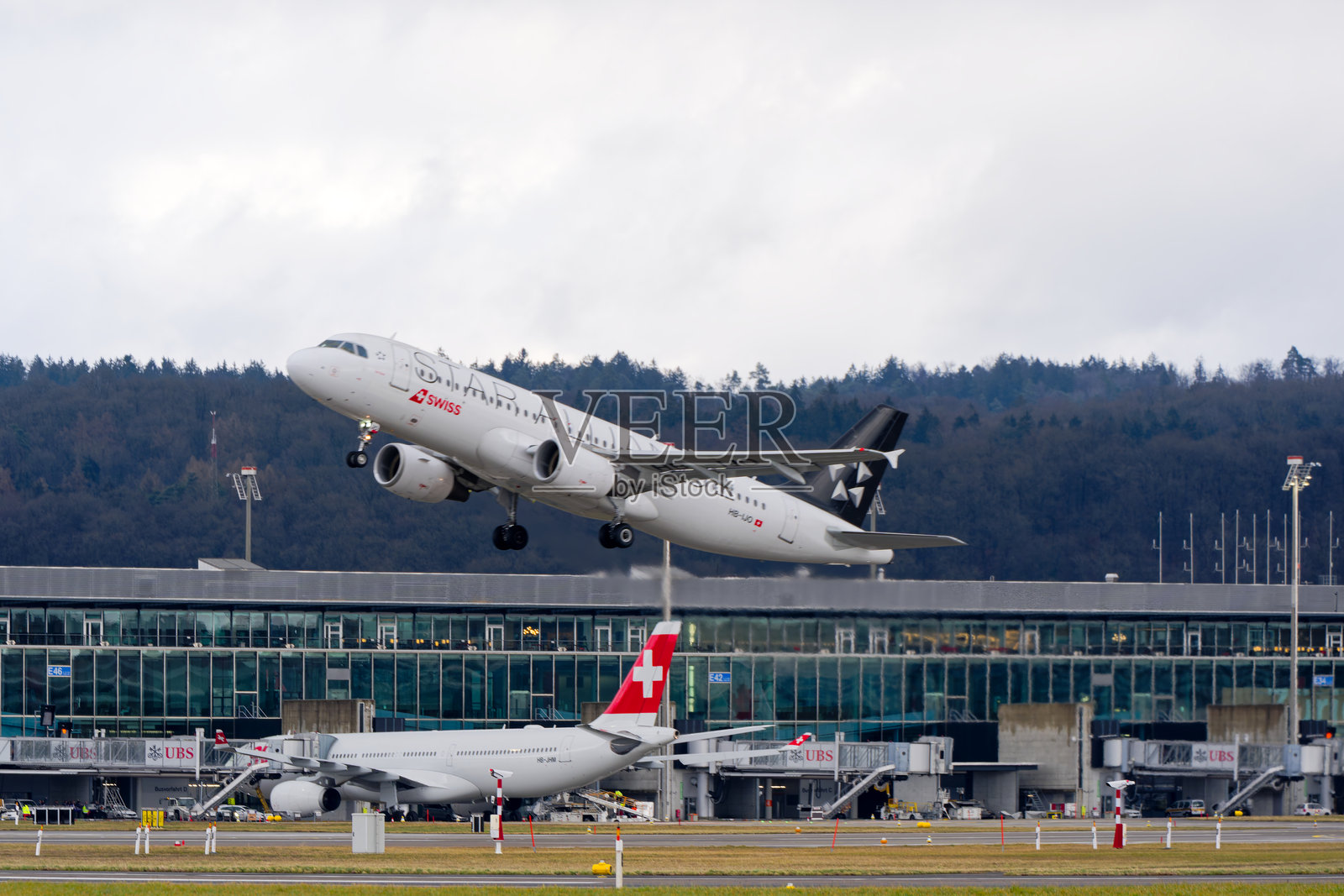 瑞士航空的空客A320-214 HB-IJO星空联盟涂装在瑞士苏黎世克洛滕机场的雨天冬季起飞。照片摄影图片