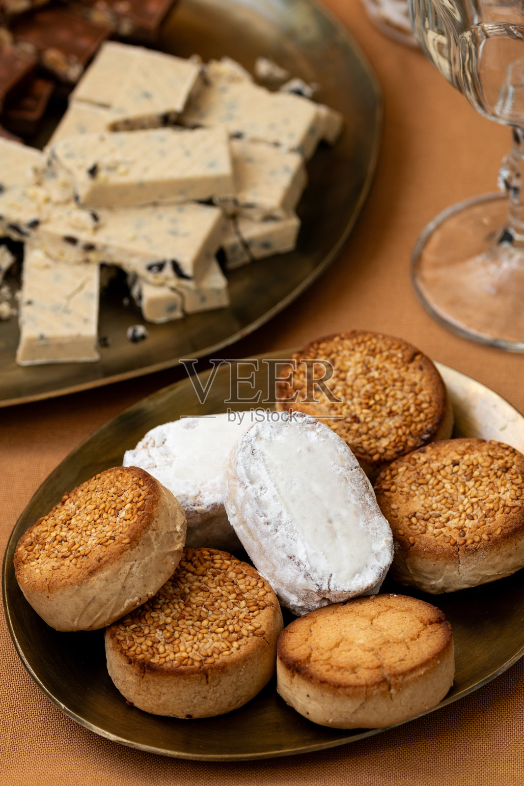 传统西班牙甜点的特写，包括芝麻粉饼和奶油饼，旁边还有牛轧糖。照片摄影图片