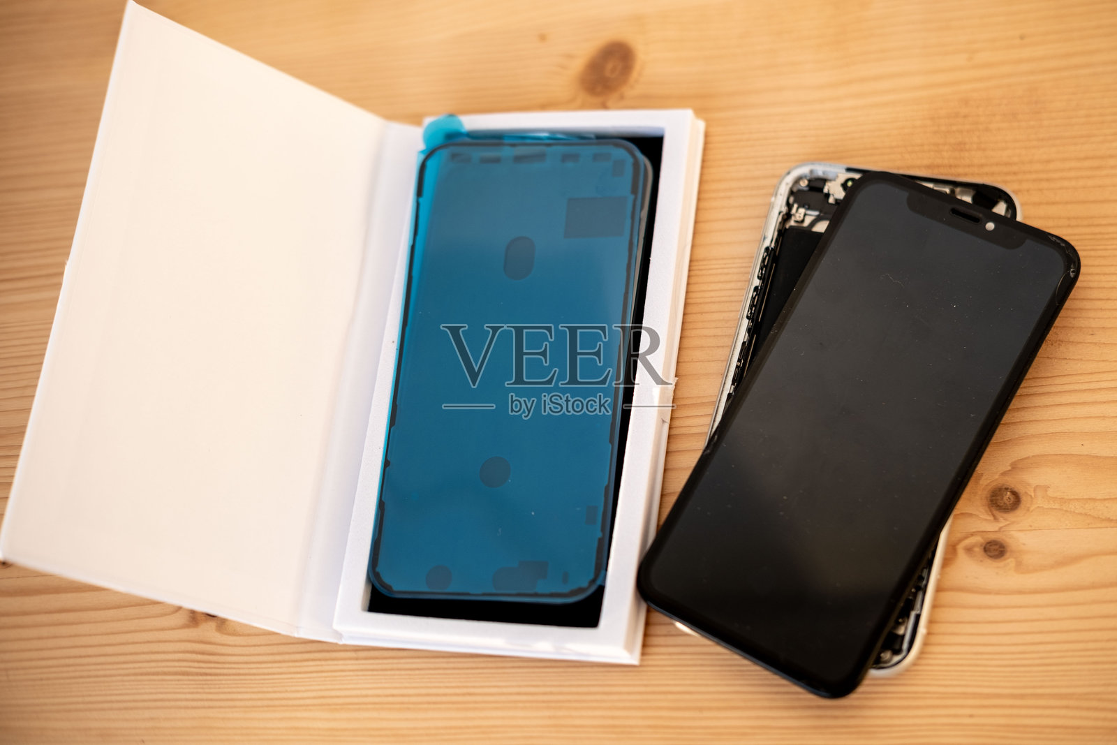 手中握着一部屏幕破裂的损坏智能手机。手机维修和维护概念，破裂的玻璃屏幕，技术支持，服务中心照片摄影图片