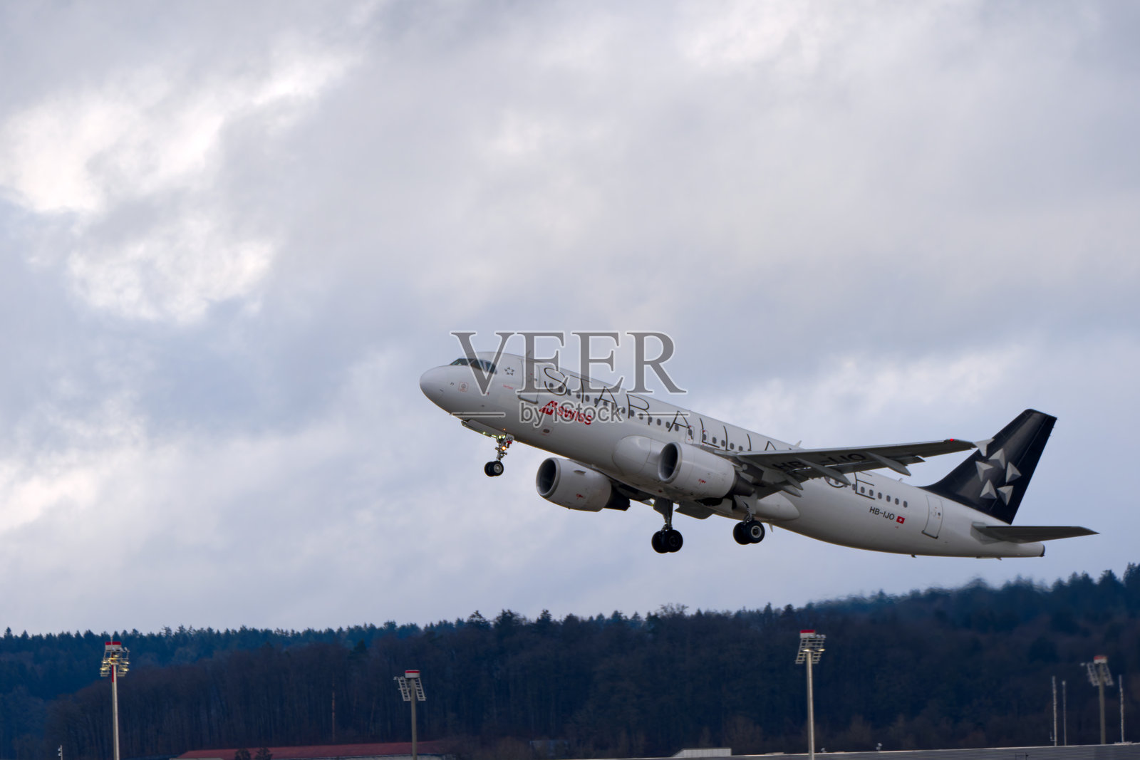 瑞士航空的空客A320-214 HB-IJO星空联盟涂装在瑞士苏黎世克洛滕机场的雨天冬季起飞。照片摄影图片