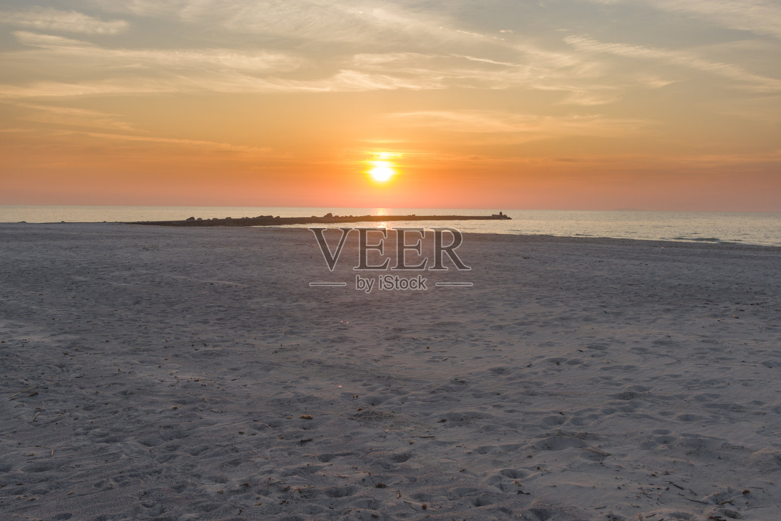 日落时分的海洋与略显多云的天空照片摄影图片