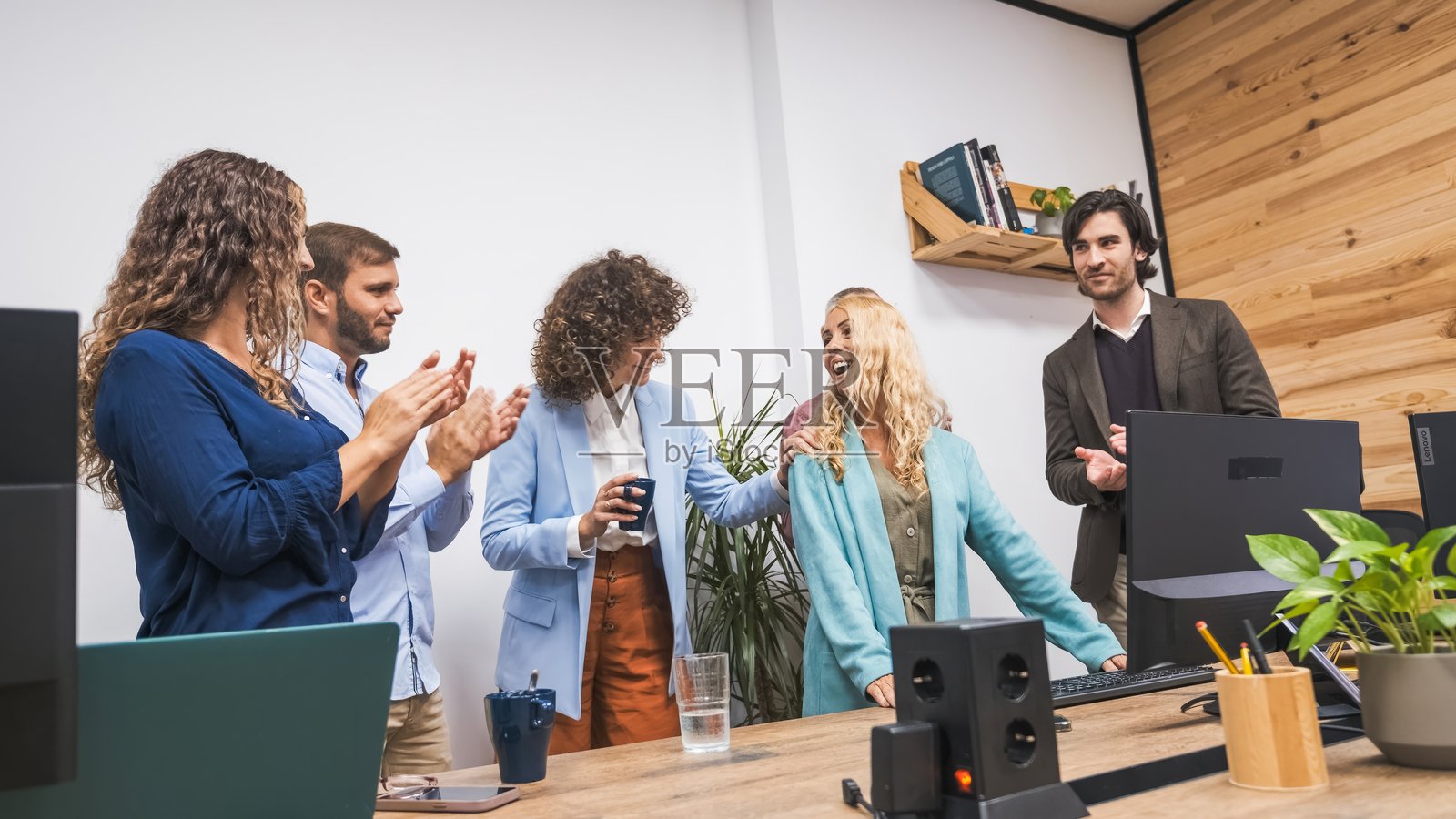 同事们在办公室里赞赏这位成功演讲的女商人照片摄影图片