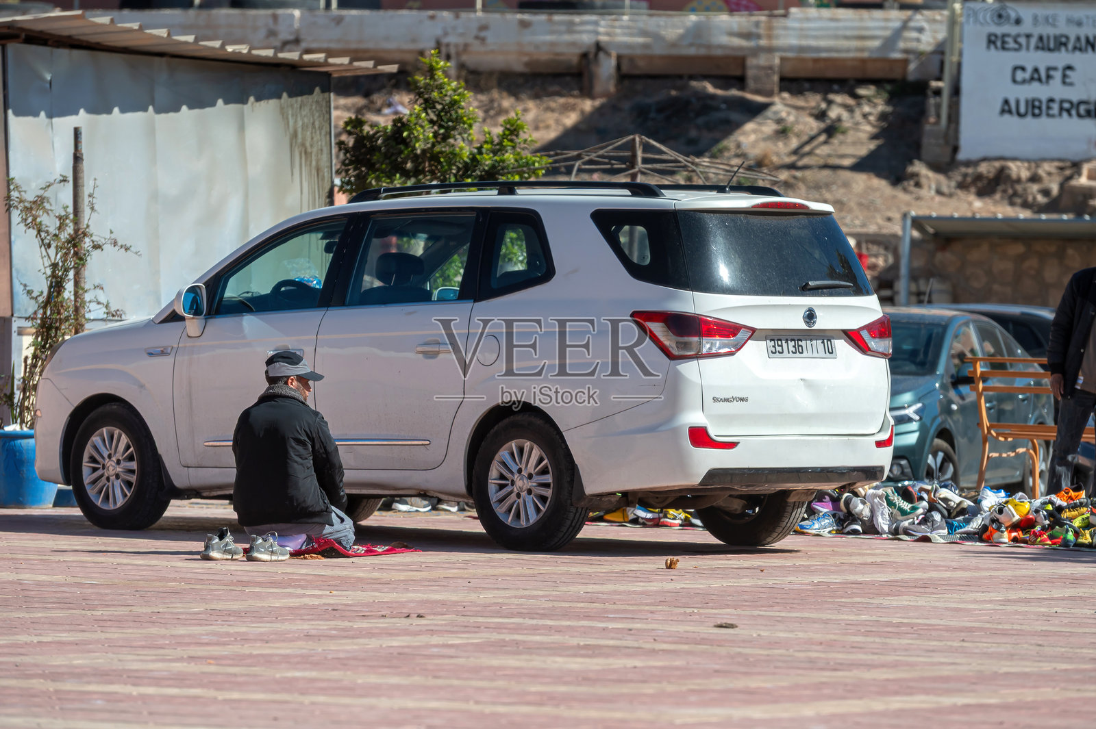 一群人在摩洛哥热闹的街道上聚集在白色车辆旁进行祈祷照片摄影图片