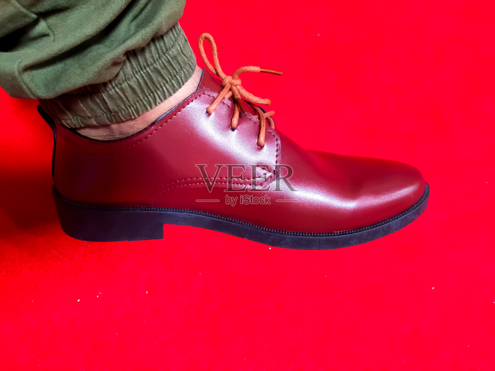 红色背景上的男士时尚鞋。照片摄影图片