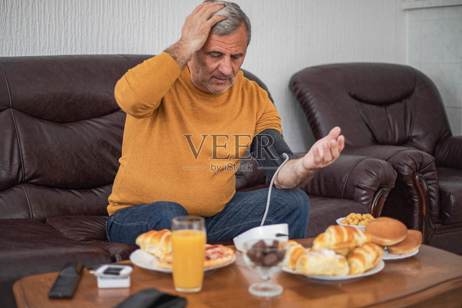 心血管问题，男人在饭前测量自己的血压照片摄影图片