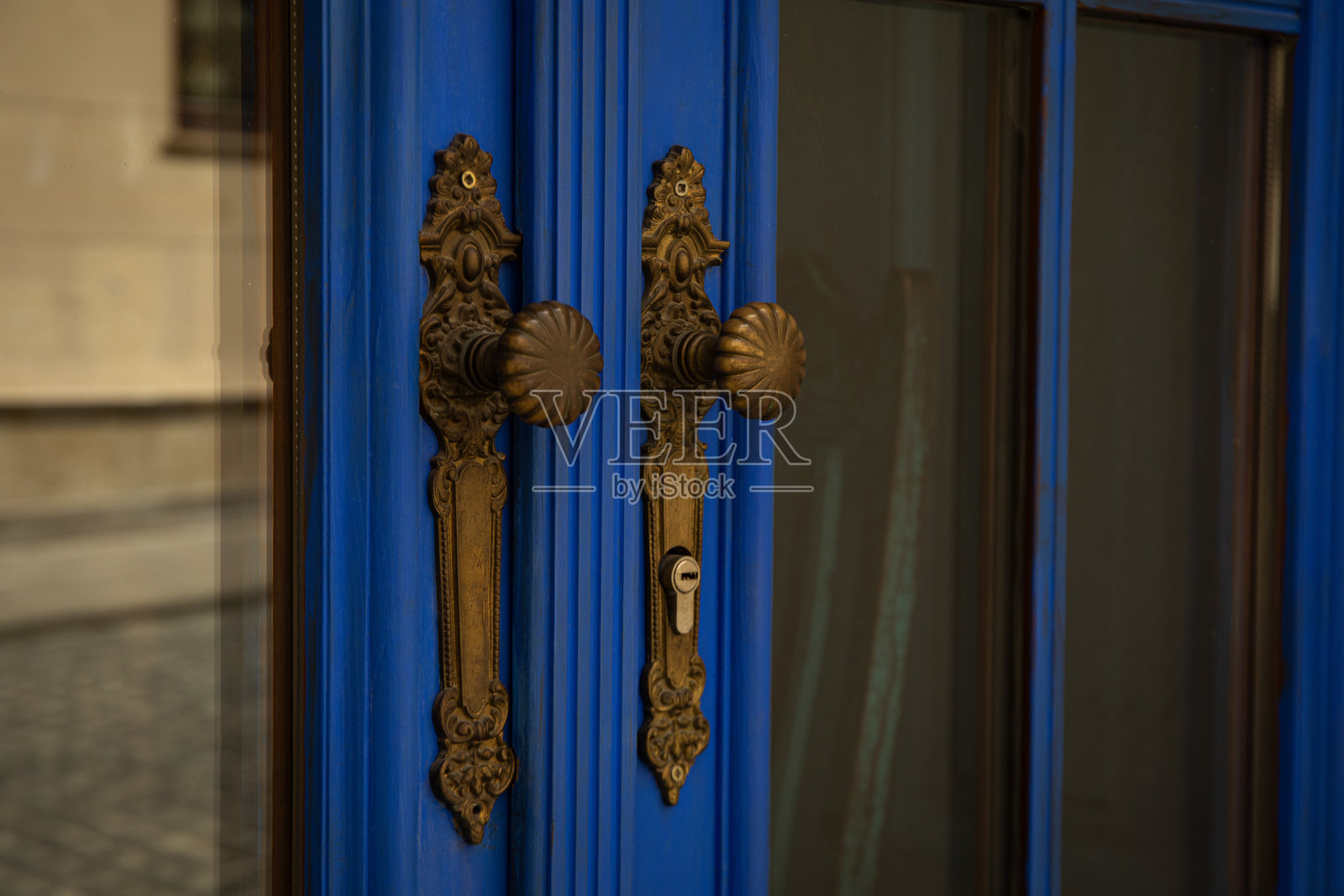 一扇美丽的蓝色门，配有精美的复古把手照片摄影图片
