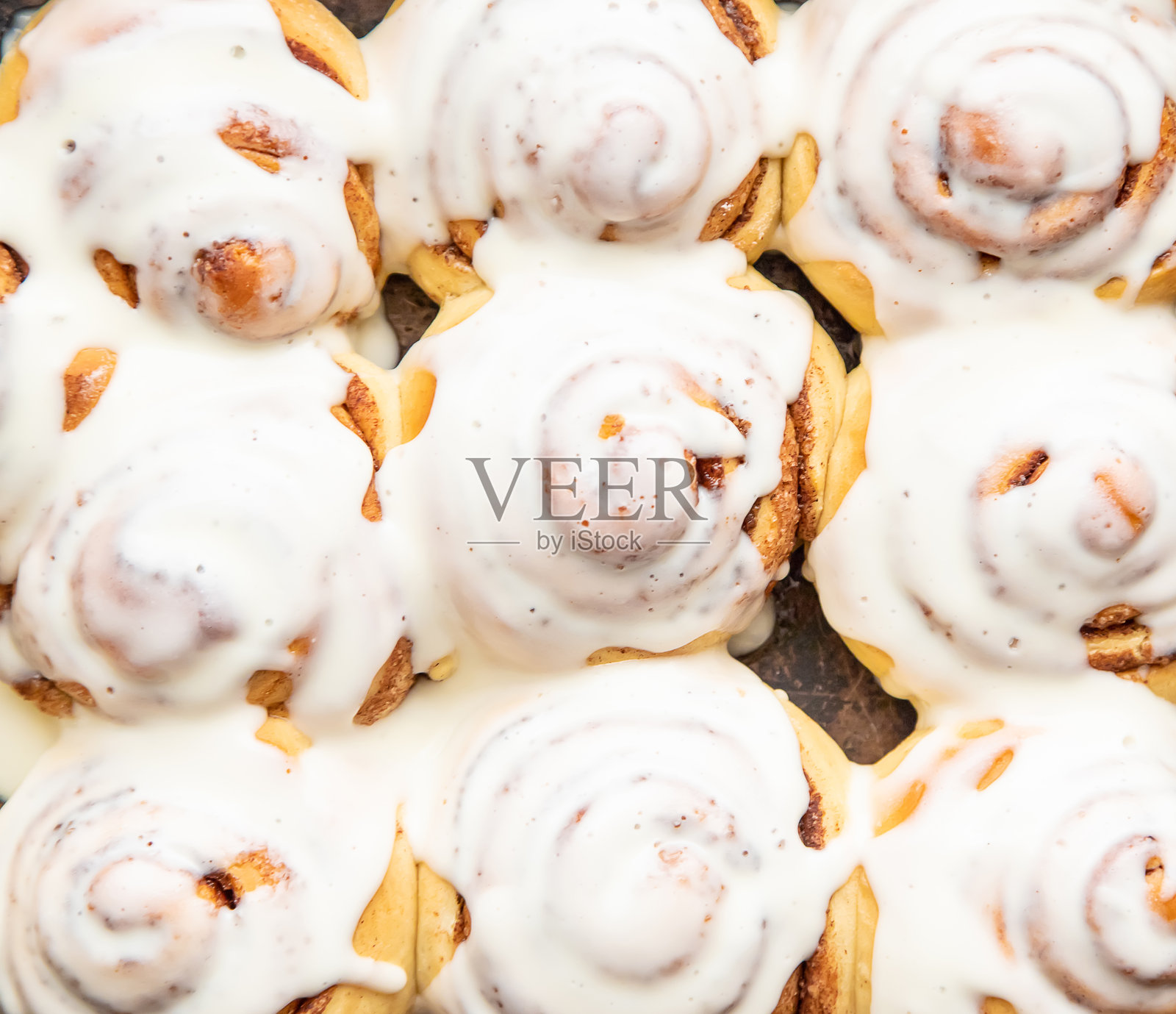 自制的肉桂卷淋上糖霜，留白空间照片摄影图片