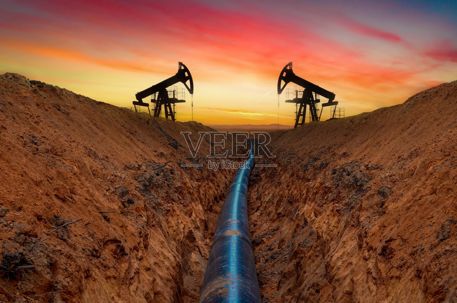 日落时的原油抽油机。化石原油生产。石油钻井平台，钻井塔。油田中的抽油机。照片摄影图片