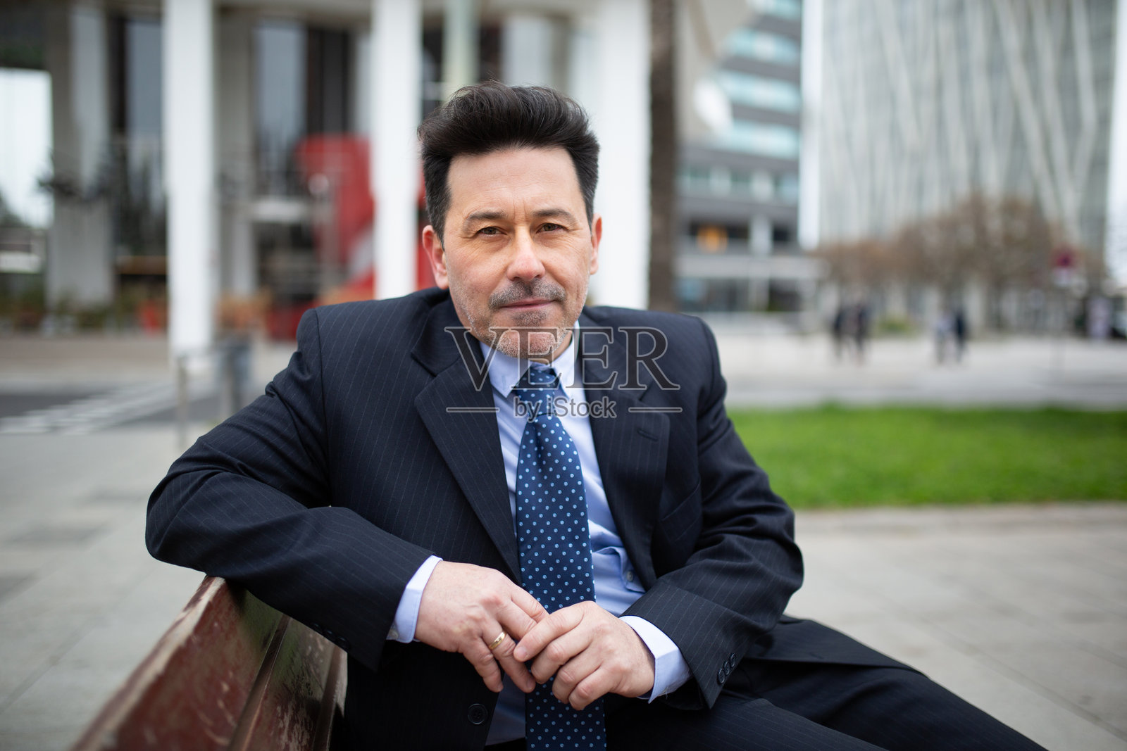 成熟的拉丁裔商人在城市的长椅上坐着照片摄影图片