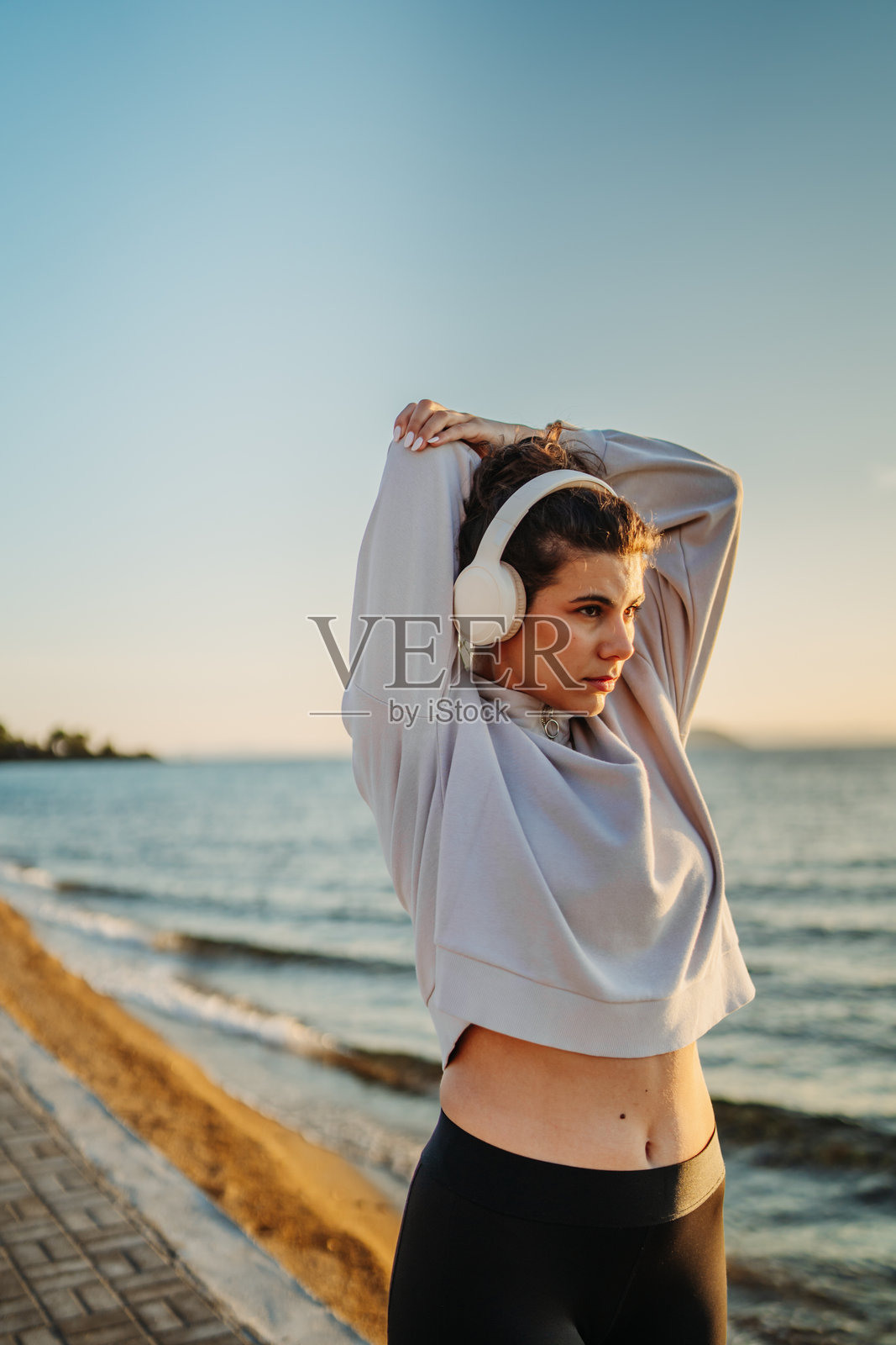 年轻的白人女性在日落时分在海滩上跑步或慢跑照片摄影图片