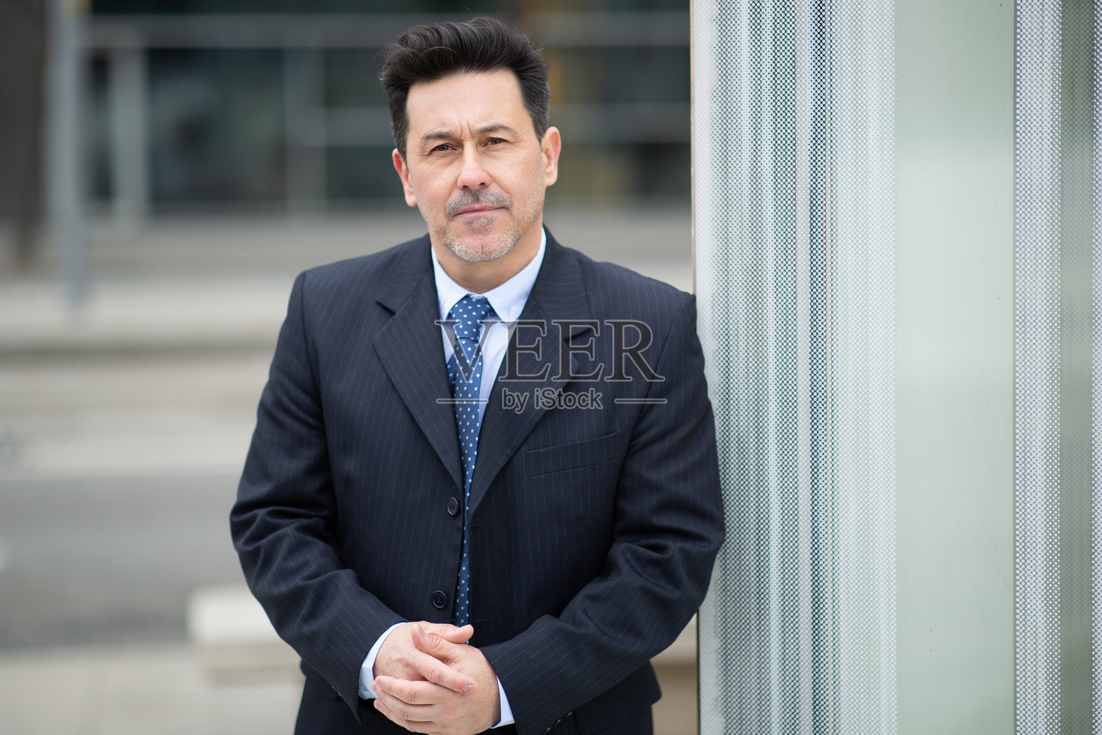 穿着西装的成熟男性在户外站立的肖像照片摄影图片