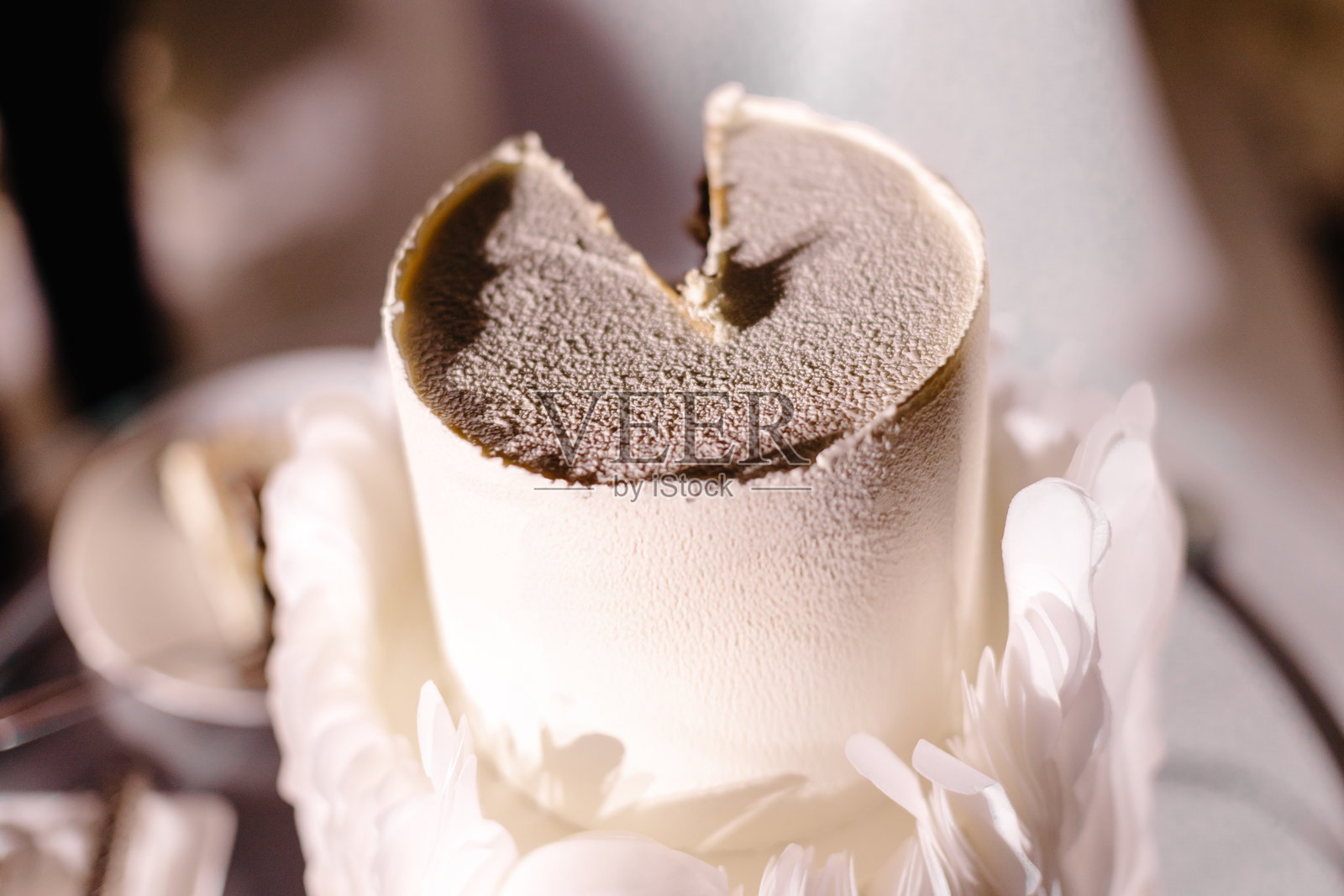 美味的白色慕斯婚礼蛋糕，上面装饰着羽毛，摆放在桌子上照片摄影图片