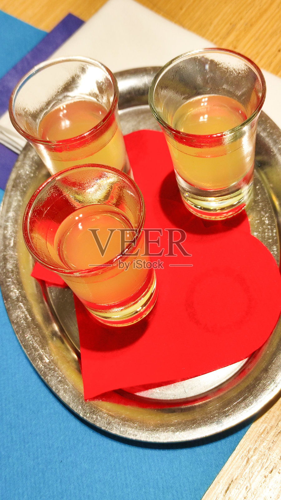 柠檬酒杯放在银色托盘上，搭配红色餐巾，展现了比比翁海滨环境中的明亮意大利清爽饮品。照片摄影图片