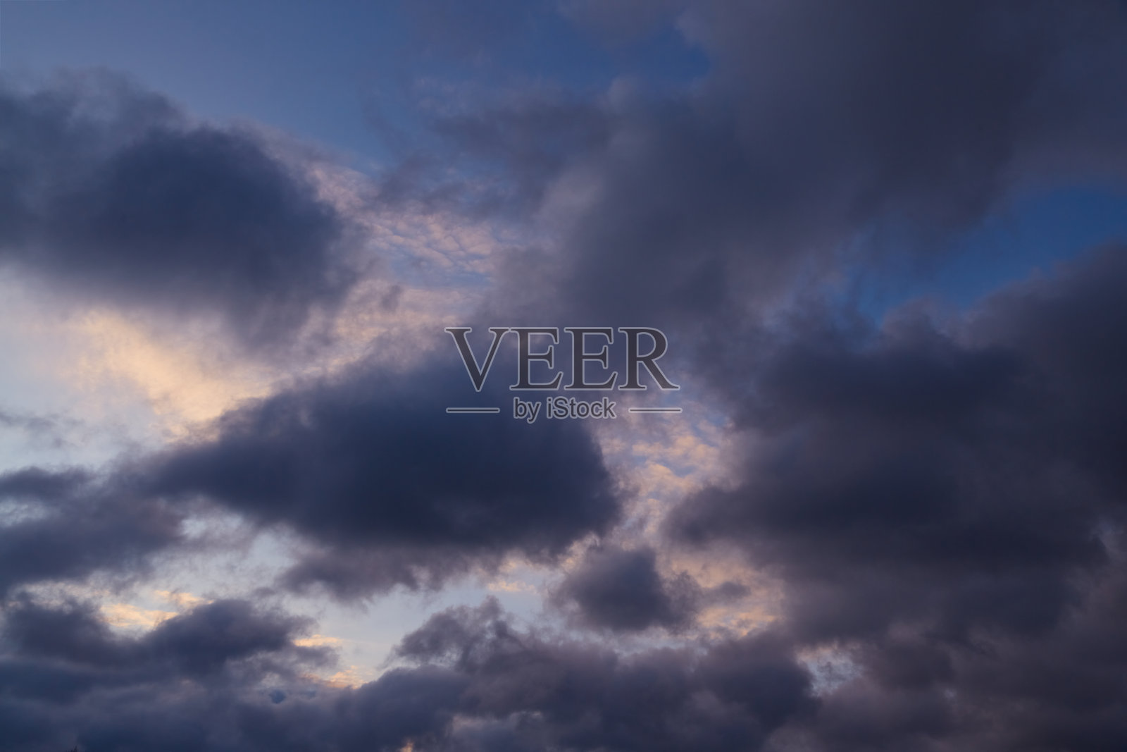 在落日的粉色光芒中，黑暗的云彩在地平线上聚集，预示着雨水的来临。象征着即将到来的挑战和内心的力量。照片摄影图片