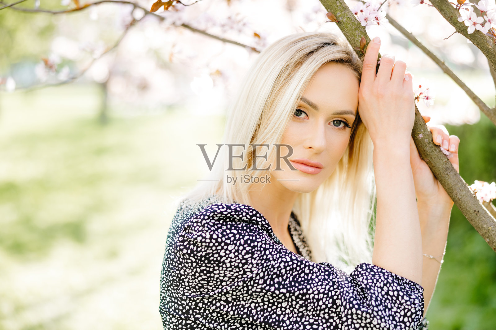 美丽的金发女人在春天的花海公园中摆姿势照片摄影图片