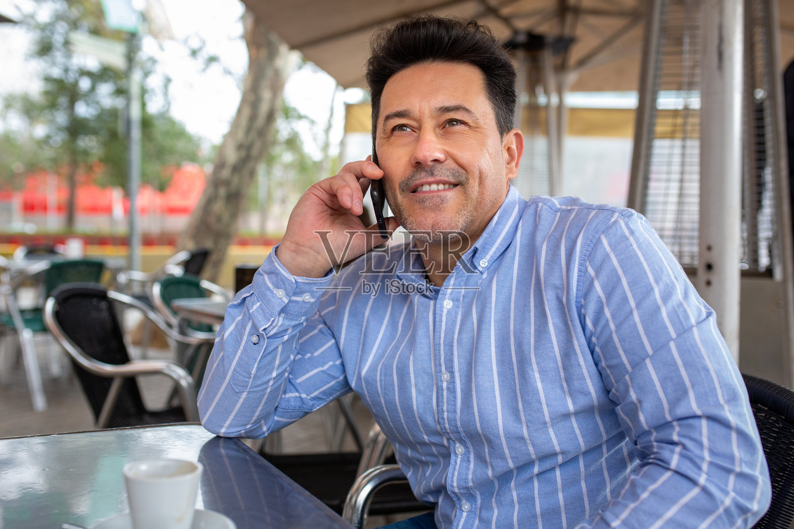 成熟男性在街边咖啡馆使用手机照片摄影图片