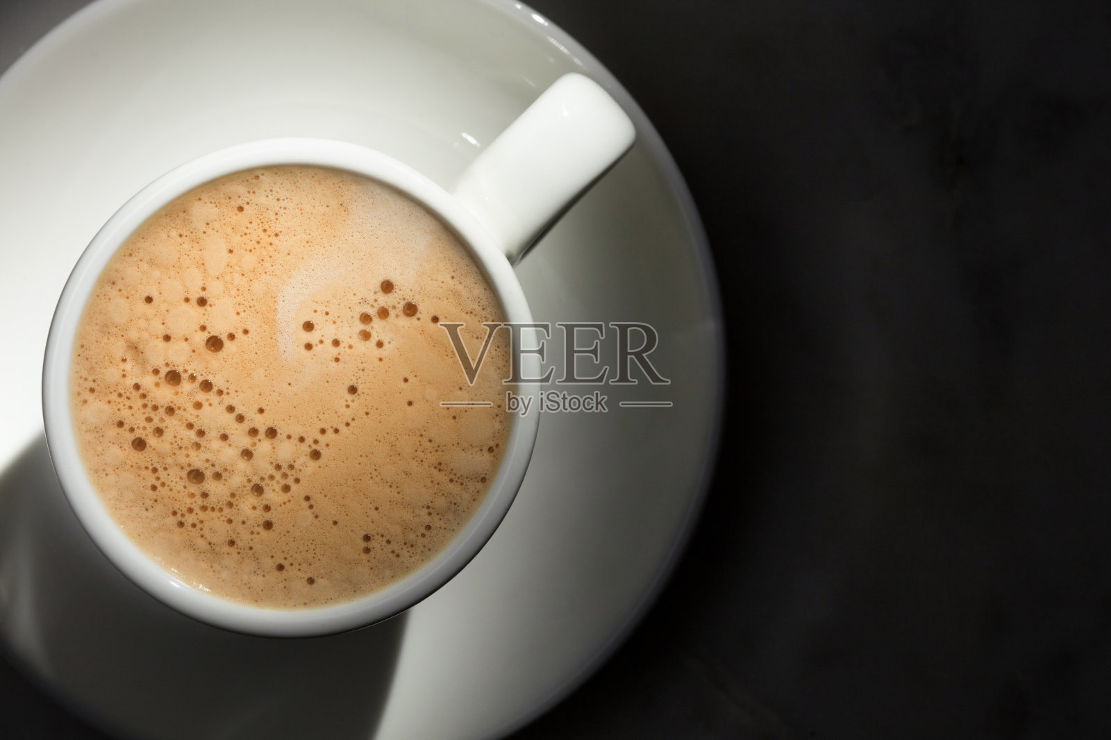 黑暗中的咖啡杯。照片摄影图片