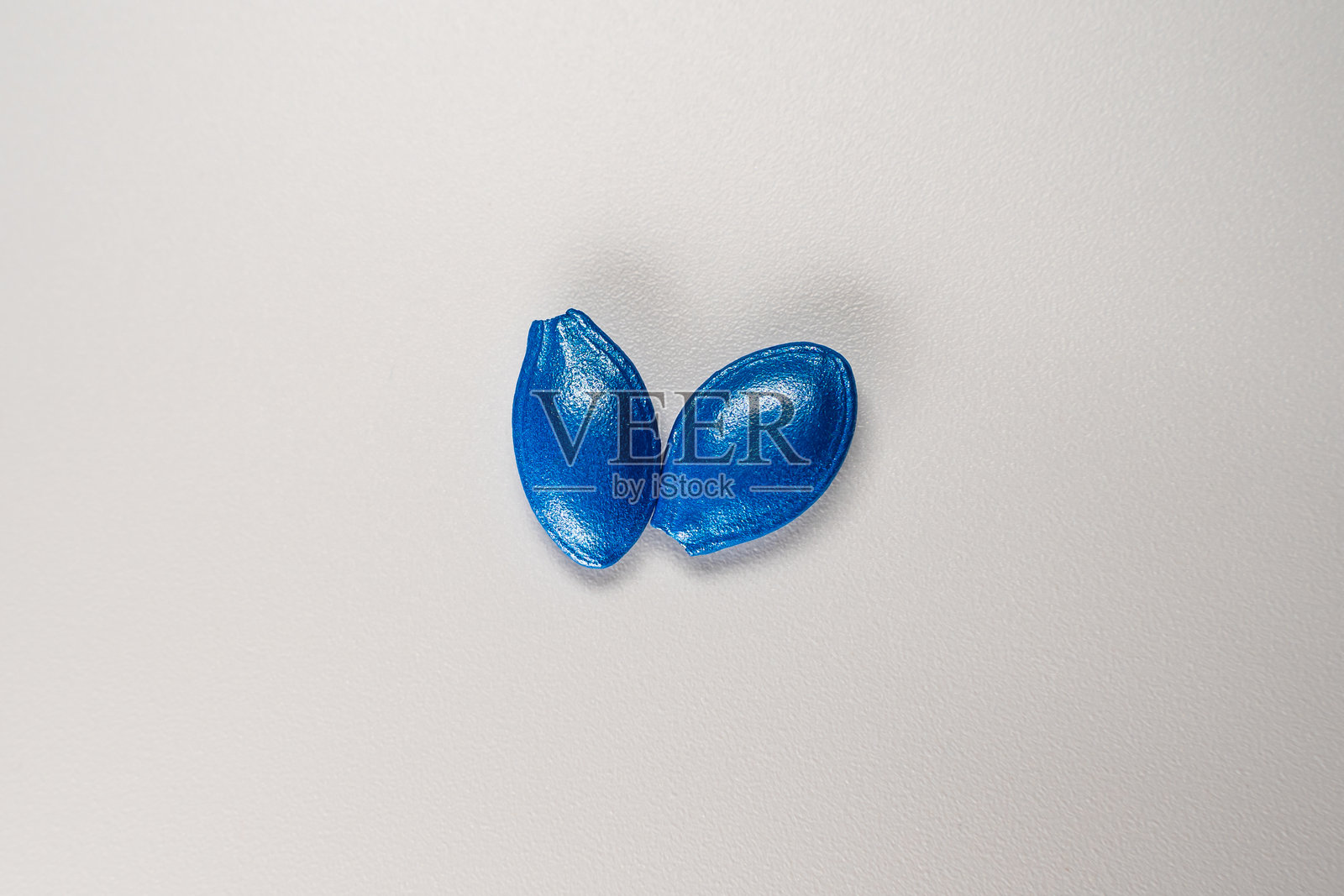 两颗蓝色西葫芦种子的特写，背景为白色照片摄影图片