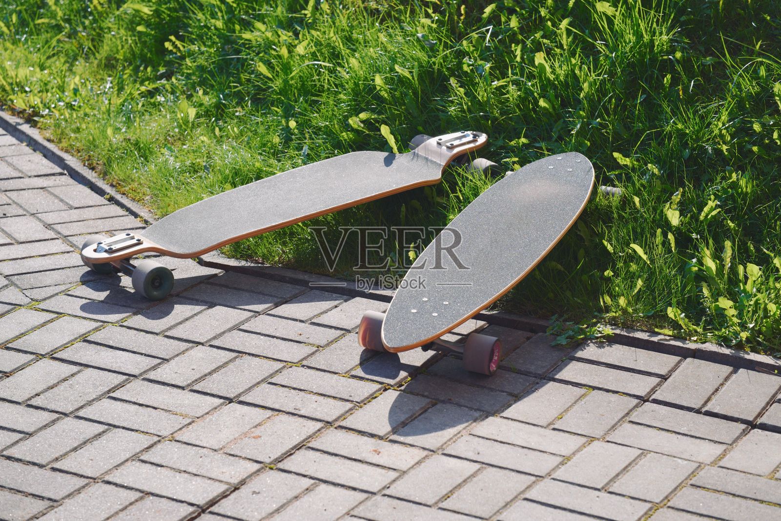 阳光明媚的小道上的长板滑板照片摄影图片