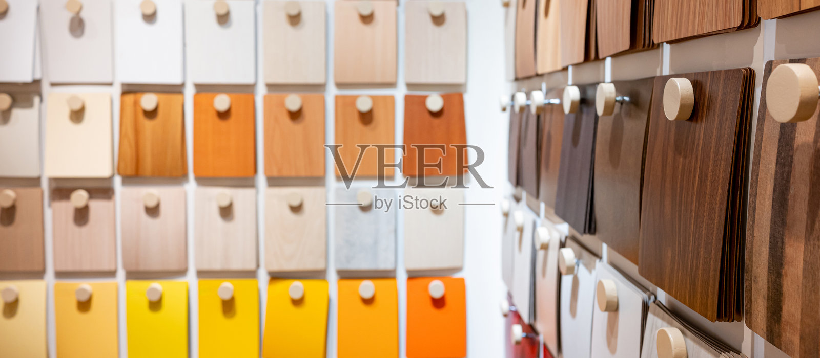 色彩丰富的木质层压样品集合在材料库中。各种材料选择供设计师在墙面展示上悬挂。照片摄影图片