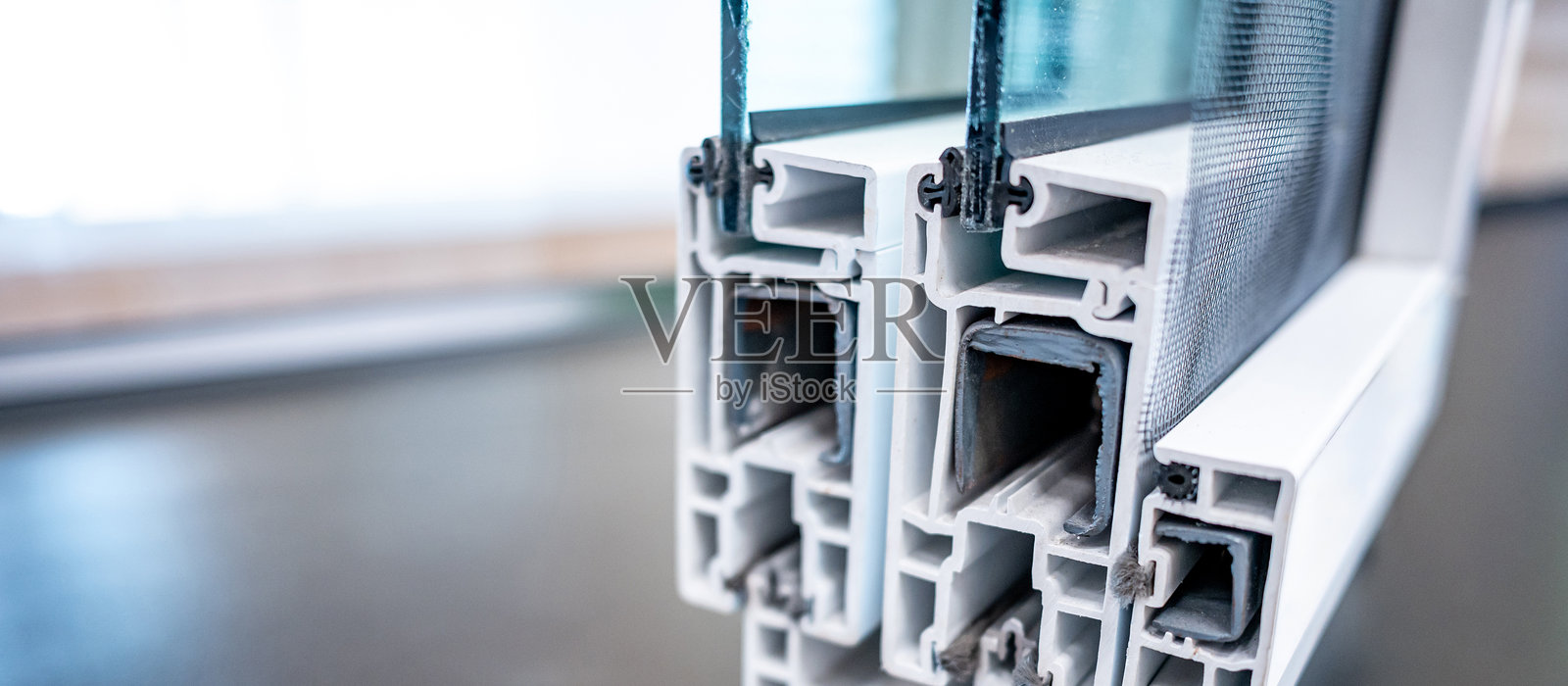 铝合金滑动门或窗框的铝型材，配有钢化玻璃和防虫网。照片摄影图片