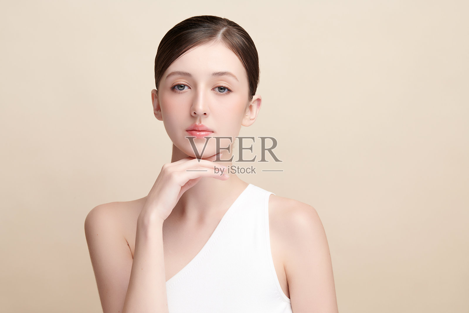 美丽的年轻女性，肤色洁净清新，背景为米色，面部护理，面部治疗，美容学，美容与水疗，女性肖像。照片摄影图片