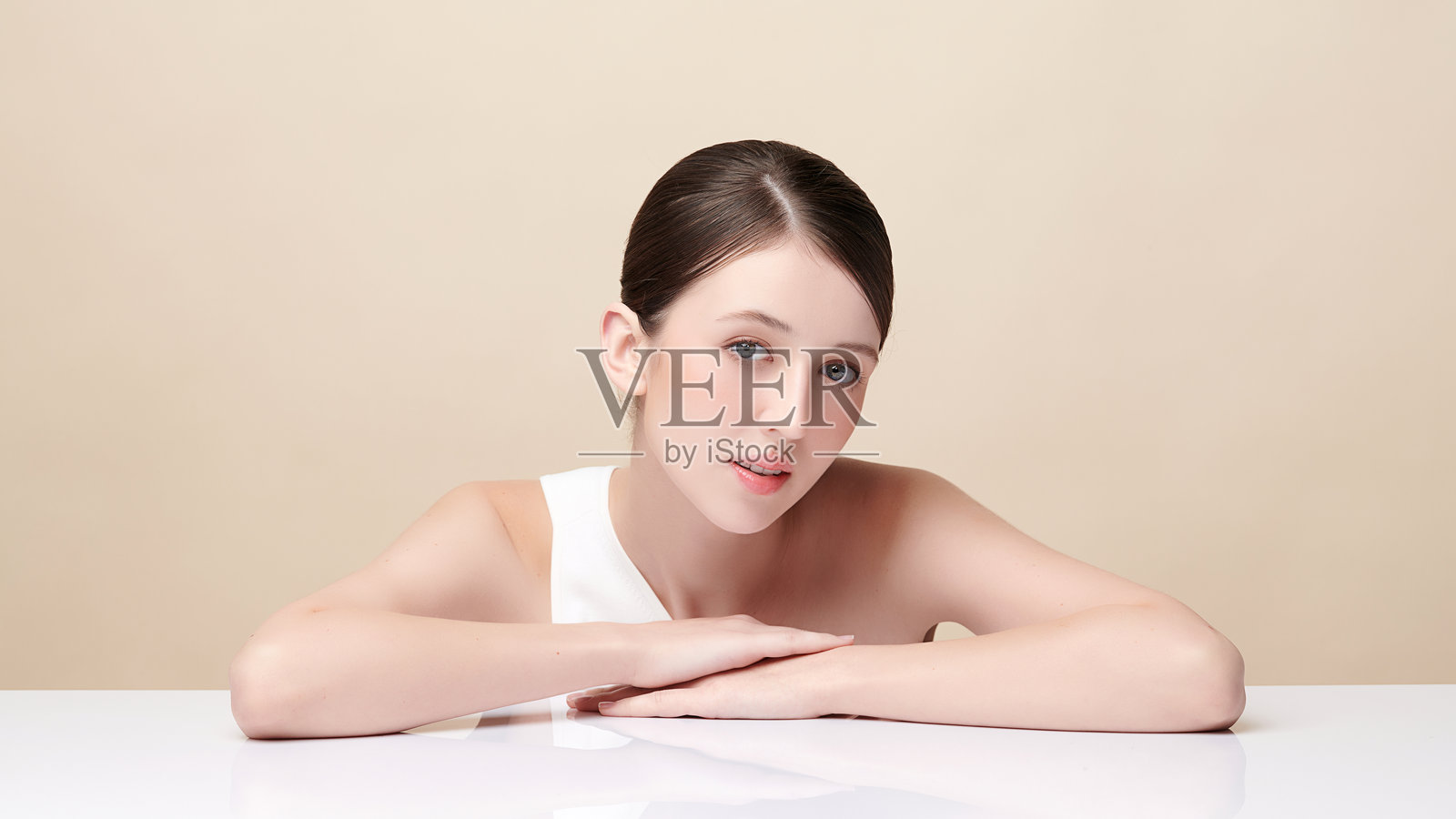 美丽的年轻女性，肤色洁净清新，背景为米色，面部护理，面部治疗，美容学，美容与水疗，女性肖像。照片摄影图片